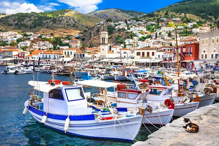 Many white painted boats moored to the waterfront in Hydra.