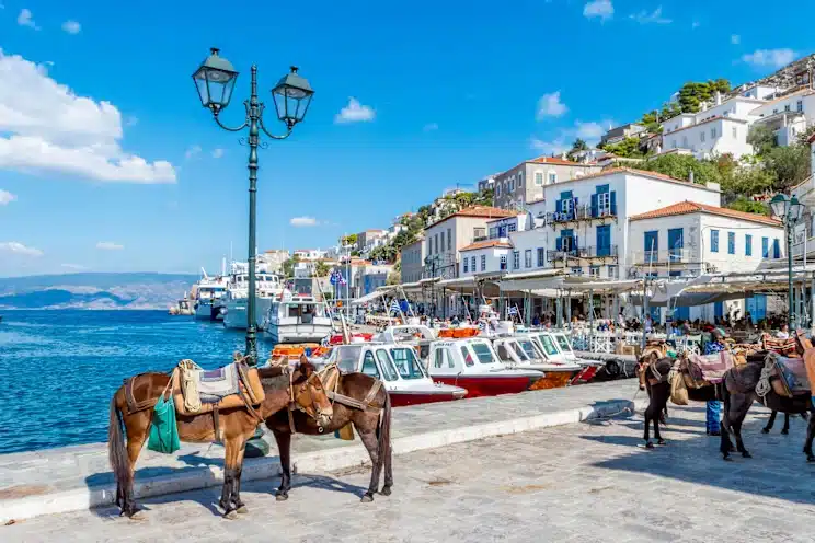 Many white painted boats moored to the waterfront in Hydra.